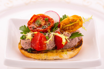 An eggplant baked with dried tomatoes on bruschetta