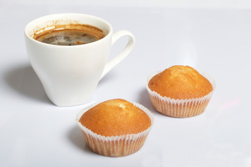 A cup of freshly brewed coffee and muffins. On a white background.