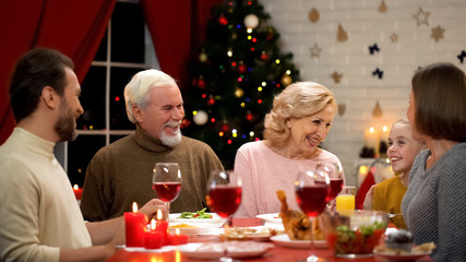 Family laughing sincerely during Christmas dinner, traditions and togetherness