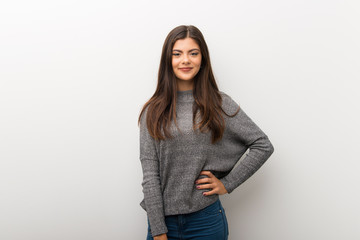Teenager girl on isolated white backgorund posing with arms at hip and smiling
