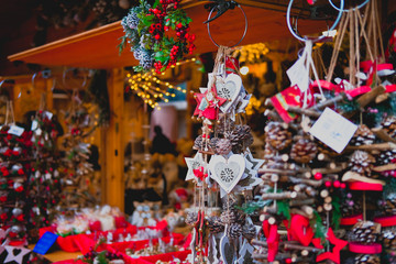 Festive decorations handmade of natural sticks and bumps. Wooden garlands in rustic style hanging on Christmas market.