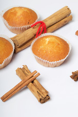 Fresh tasty muffins. Nearby are cinnamon sticks and anise stars. On a white background.