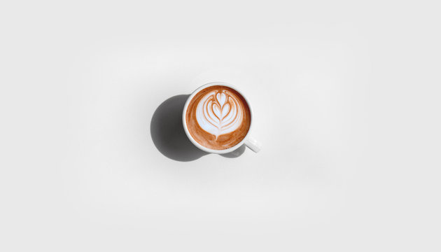 Top view of hot coffee drink cappuccino with leaf froth art.