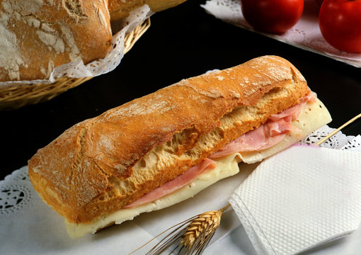 barra de pan con queso y jam&oacute;n cocido.