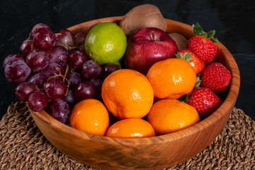 Healthy food: mix from fruits in bowl, old marble background, selective focus