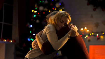 Awesome tender couple hugging near Christmas tree, celebrating holiday, love