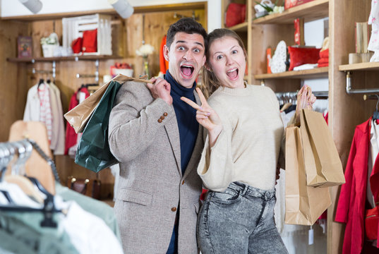 Young woman and man are standing satisfied with packadge after shopping