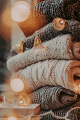 A bunch of sweaters, light bulbs, lanterns, cozy winter interior details, home decor and comfort.