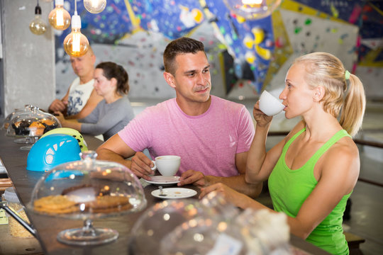 Climbers discussing over cup of coffee in sports bar at gym