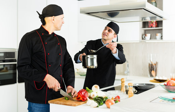 Male chefs  in black uniform having quarrel at workplace on kitchen