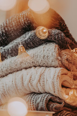 A bunch of sweaters, light bulbs, lanterns, cozy winter interior details, home decor and comfort.