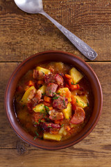 Goulash soup bograch in a bowl. Hungarian dish. Stew, made with beef, bacon, sausages, potatoes and carrots. View from above, top studio shot