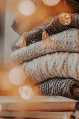 A bunch of sweaters, light bulbs, lanterns, cozy winter interior details, home decor and comfort.
