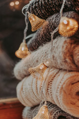 A bunch of sweaters, light bulbs, lanterns, cozy winter interior details, home decor and comfort.