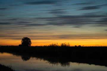 Colorful and moody evening sky over a river in The Netherlands