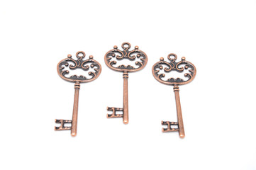 Vintage copper keys on white background close up