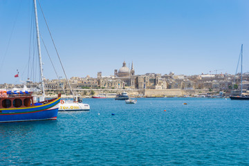 Fototapeta na wymiar VALLETTA, MALTA - June 28, 2017: Typical Seaside port in Valletta in Malta