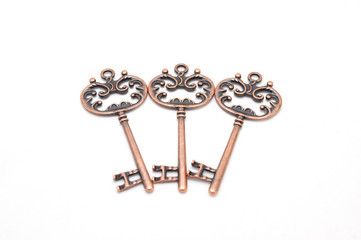 Vintage copper keys on white background close up
