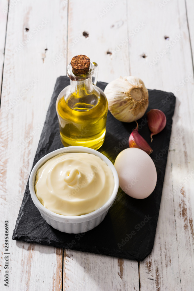 Wall mural Aioli sauce and ingredients on white wooden table 

