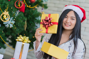 Happy woman wearing santa hat holding a gifts in Christmas and New Year holiday