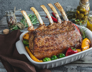 Grilled roasted rack of veal lamb chops with vegetables in ceramic baking dish. - obrazy, fototapety, plakaty