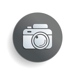 Photo camera, simple icon. White paper symbol on gray round button or badge with shadow