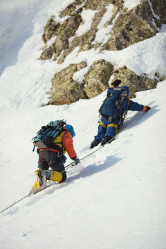 Two climbers on a snow-covered mountain slope.