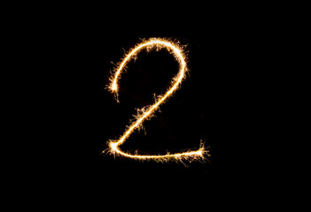 Numbers 2 or two Sparkler firework light isolated on black background