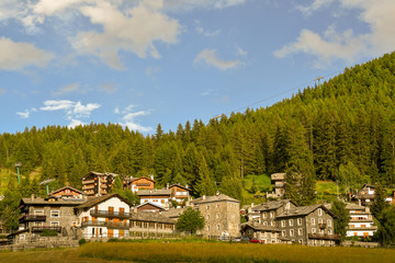 Panoramic view of a mountain village with pine forest and blue sky in summer, Cogne, Aosta Valley, Alps, Italy