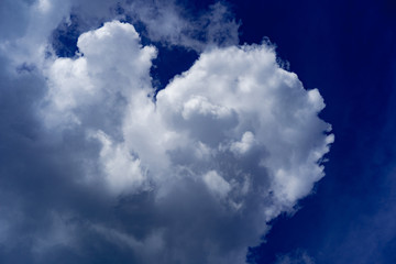 Dark blue sky and white fluffy clouds