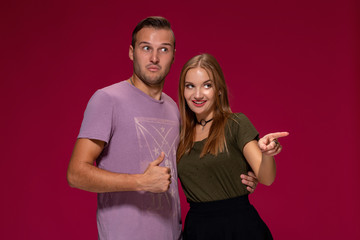 Obraz premium People, friendship, love and leisure concept - lovely couple with thumbs-up gesture on burgundy background