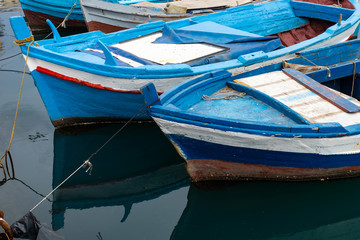 Fototapeta na wymiar Boats docked in a small harbor in a fishing village on the coast of Sicily.