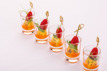 Portion giving of cheese with hot sauce and strawberry