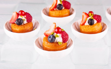 The fresh berries decorated with cream on a biscuit