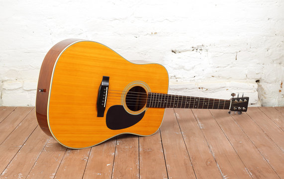 Musical instrument - Classic acoustic guitar wood and brick background