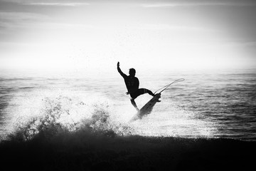 silueta de un surfista en blanco y negro y a contraluz