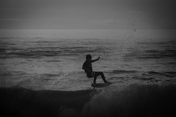 silueta de un surfista en blanco y negro y a contraluz