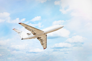 white plane flies in the blue sky through the clouds
