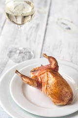 Baked quail wrapped in bacon on the plate