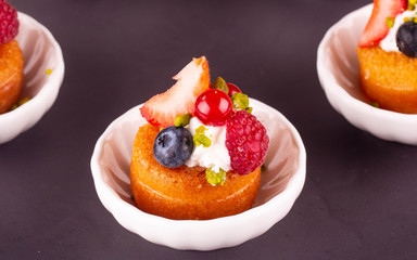 A berries dessert with whipped cream and a pistachio crumb