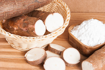 Raw cassava tuber on wooden background - Manihot esculenta