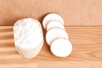 Raw cassava tuber on wooden background - Manihot esculenta