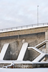 Concrete dam with staircase covered with snow.