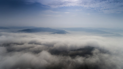 Aerial view from a drone about the Transylvanian valleys on a foggy morning, above Sic village, Transylvania,  Romania