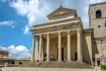 San Marino, San Marino - May 19th 2018 - Tourists and locals walking in front of a church in San Marino in a blue sky day