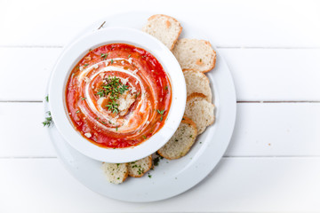 Tomato soup on white with cream and herbs. Top view, copy space