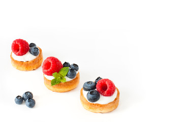 Three Belgian waffles with blueberry, raspberries and fresh mint on white background