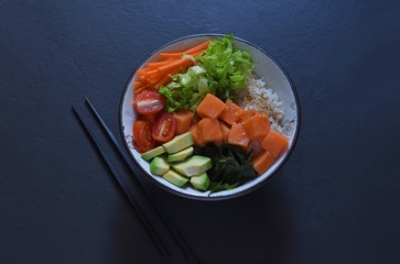 Traditional Hawaiian dish Poke Bowl on a dark background 