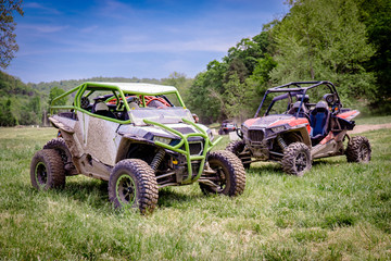 Two Muddy UTV Side by Side Off Road Vehicles