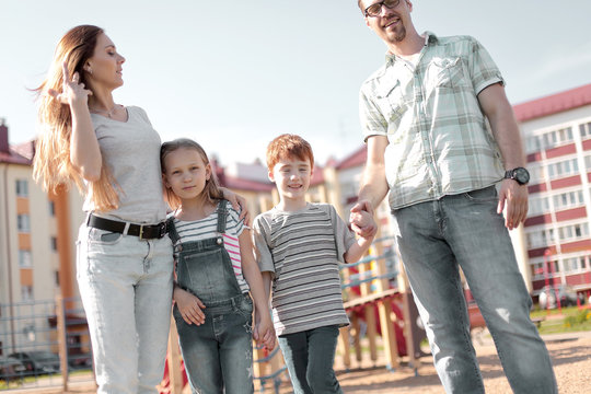 Happy Family Standing In The Courtyard Of An Apartment Building